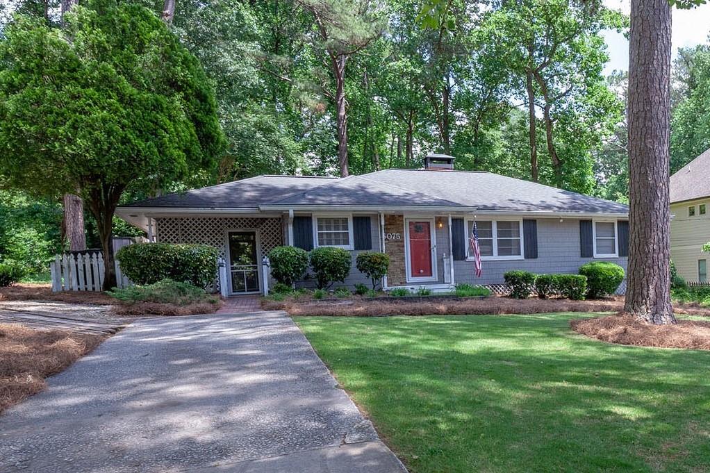 6075 Harleston Road Northeast Atlanta, GA 30328 - Photo 1 of 1 a front view of a house with a yard