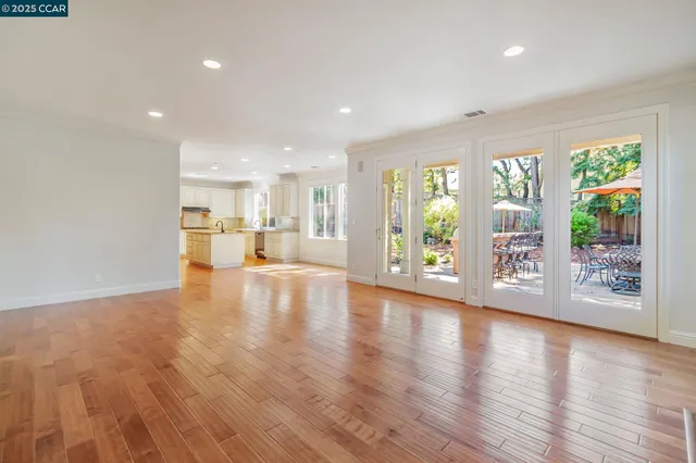 a view of a kitchen with kitchen island a sink wooden floor and a large window
