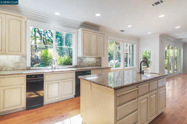 a kitchen with kitchen island a counter top space cabinets and stainless steel appliances