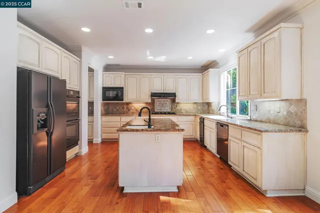 a kitchen with stainless steel appliances granite countertop a sink stove and refrigerator