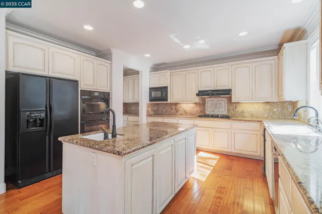 a kitchen with stainless steel appliances granite countertop a sink stove and cabinets