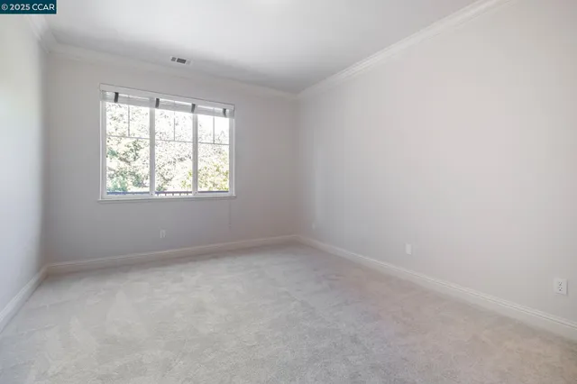 a view of a big room with windows and chandelier fan
