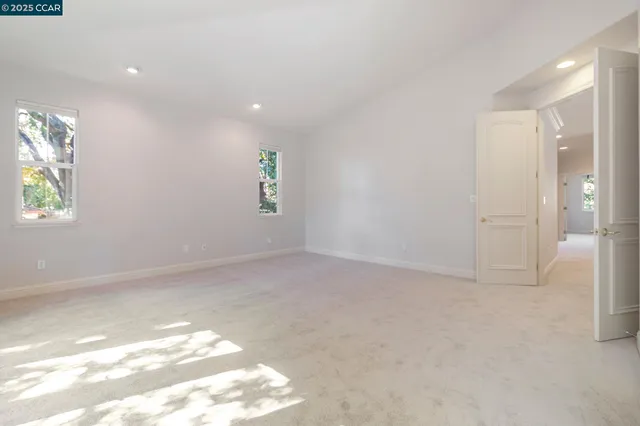 a spacious bathroom with a double vanity sink a mirror a bathtub and next to a window