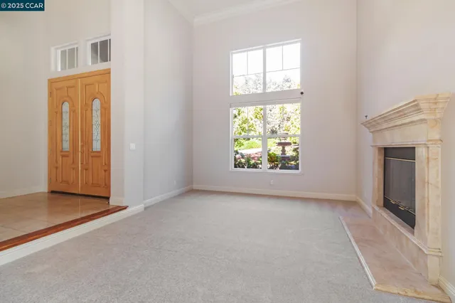 an empty room with windows and fireplace
