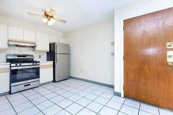 a kitchen with a refrigerator sink and cabinets