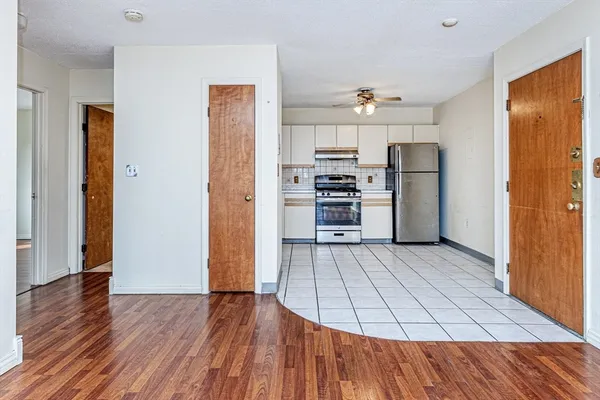 a kitchen with stainless steel appliances a refrigerator and wooden floor
