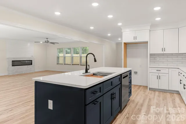 a kitchen with kitchen island wooden cabinets and sink