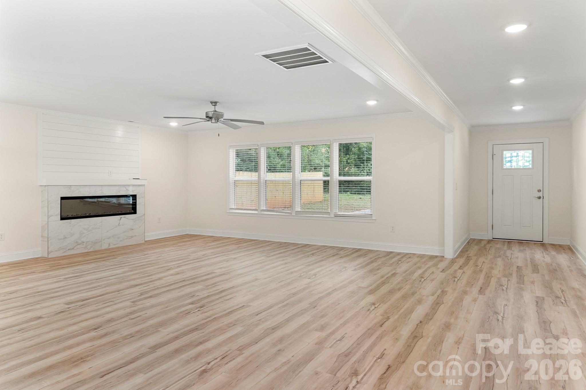 116 Maple Grove Church Road Matthews, NC 28104 - Photo 2 of 41 an empty room with wooden floor and windows