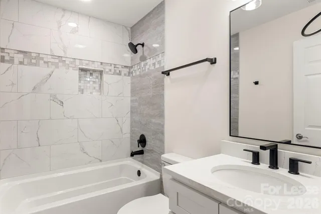 an empty room with wooden floor closet and windows