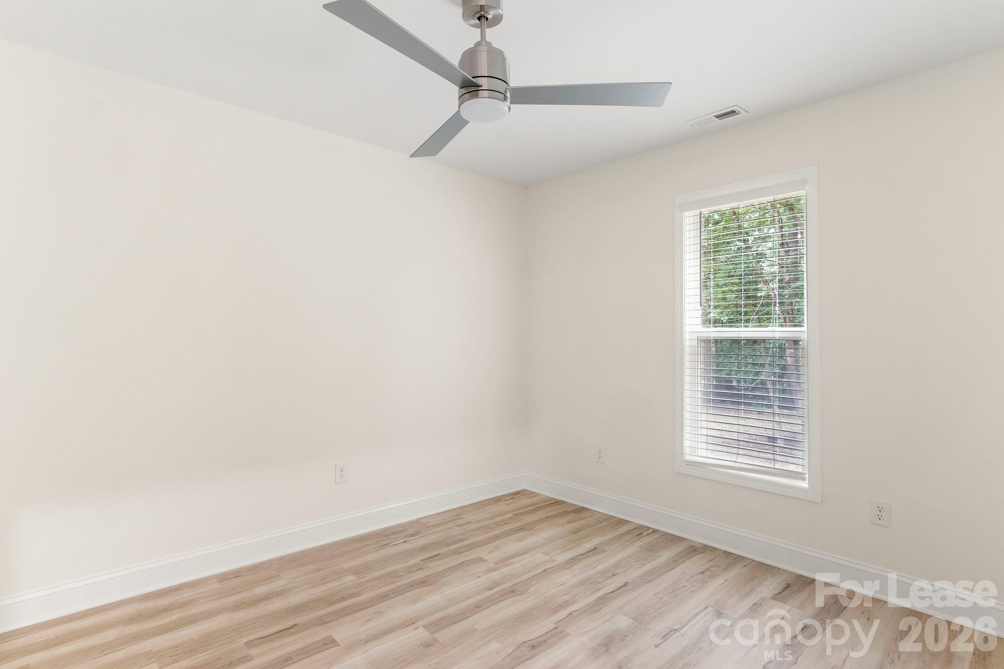 116 Maple Grove Church Road Matthews, NC 28104 - Photo 32 of 41 a view of an empty room with wooden floor and a window