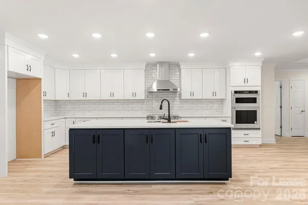 a kitchen with granite countertop white cabinets and stainless steel appliances