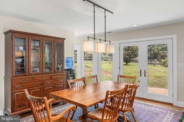 a dining room with furniture a chandelier and wooden floor