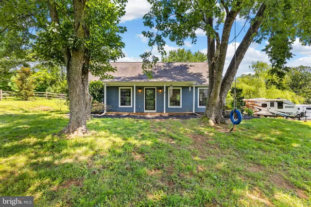a view of a house with backyard and a tree