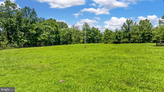 a view of a house with pool and a yard