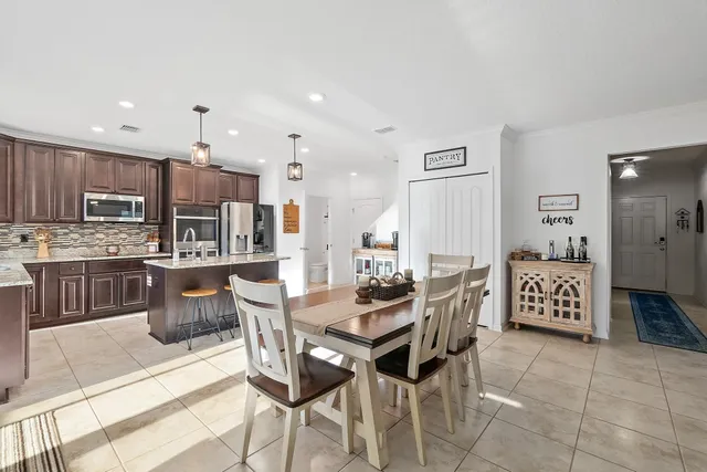 a kitchen with stainless steel appliances kitchen island granite countertop a sink and a refrigerator