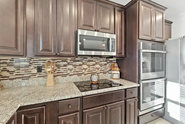 a kitchen with granite countertop a sink stainless steel appliances and cabinets
