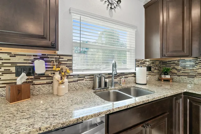 a kitchen with sink and granite counter tops