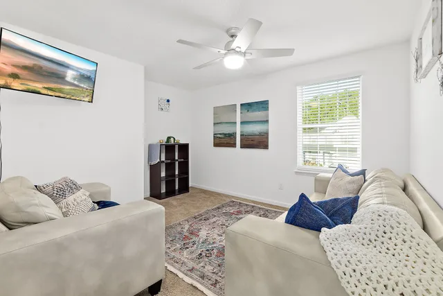 a living room with furniture and two window