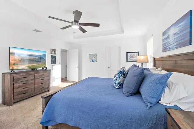 a bedroom with a large bed and flat tv screen