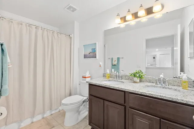 a bathroom with a granite countertop sink a toilet and a mirror