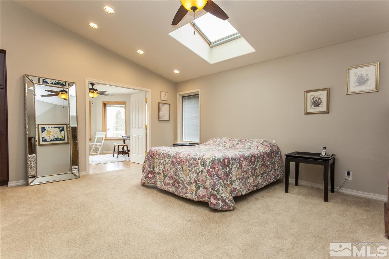 3985 Riverhaven Drive Reno, NV 89519 - Photo 12 of 25 a spacious bedroom with a bed and a chandelier