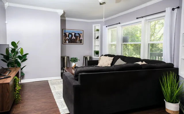 a bed sitting in a bedroom next to a window with potted plant
