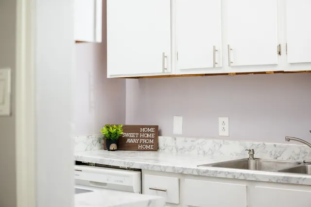 a kitchen with granite countertop white cabinets and a sink