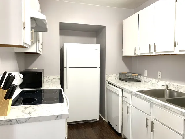 a kitchen with a sink a refrigerator and cabinets