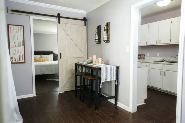 a kitchen with a table chairs refrigerator and cabinets