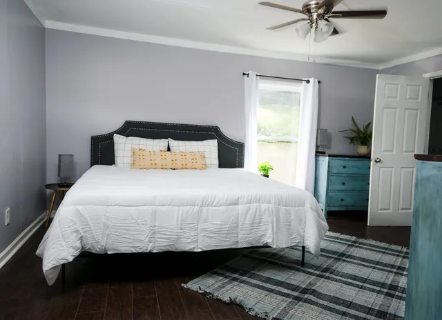 a bedroom with a bed and a flat tv screen on dresser