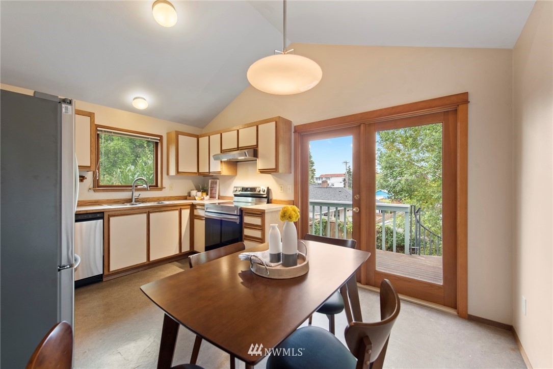 723 North 87th Street Seattle, WA 98103 - Photo 5 of 29 a kitchen with a table chairs a stove and a refrigerator