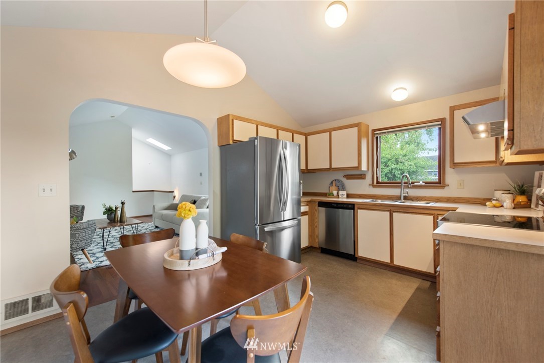 723 North 87th Street Seattle, WA 98103 - Photo 6 of 29 a kitchen with sink refrigerator and cabinets
