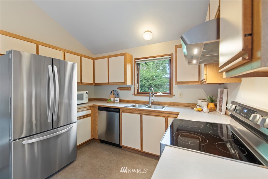 723 North 87th Street Seattle, WA 98103 - Photo 7 of 29 a kitchen with stainless steel appliances a refrigerator sink and cabinets