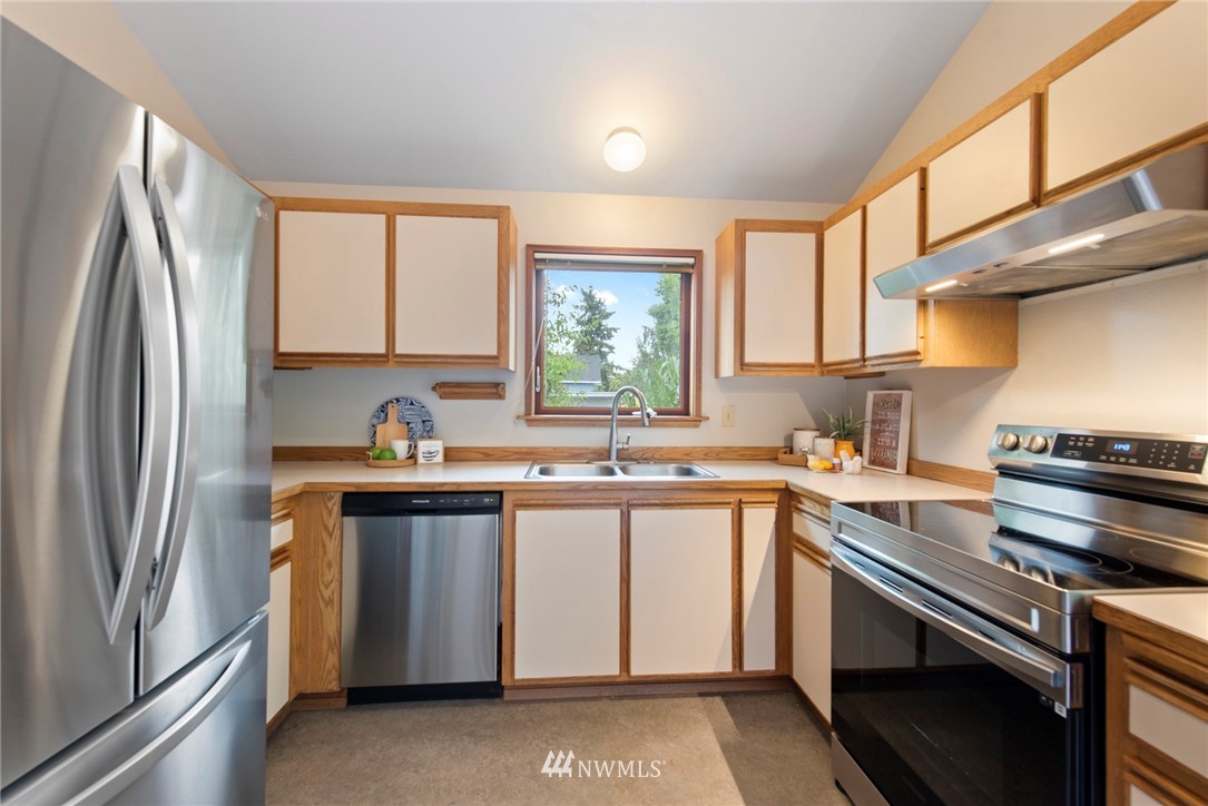 723 North 87th Street Seattle, WA 98103 - Photo 8 of 29 a kitchen with a sink stove and refrigerator