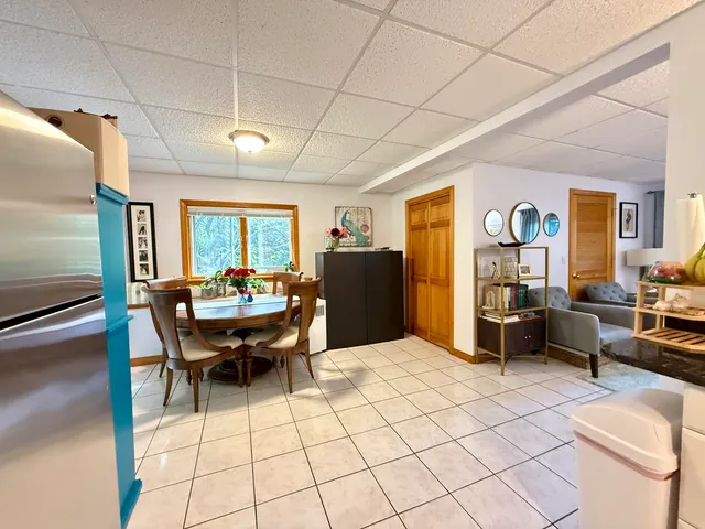 a living room with furniture a table and a refrigerator
