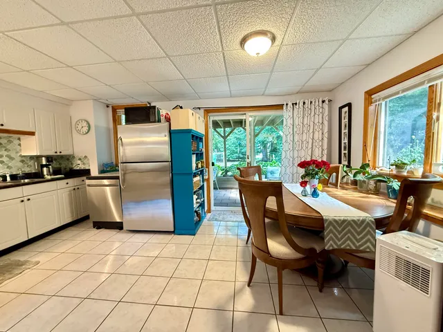 a kitchen with granite countertop a table chairs refrigerator and microwave