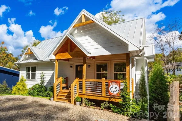 a view of a house with a yard and potted plants