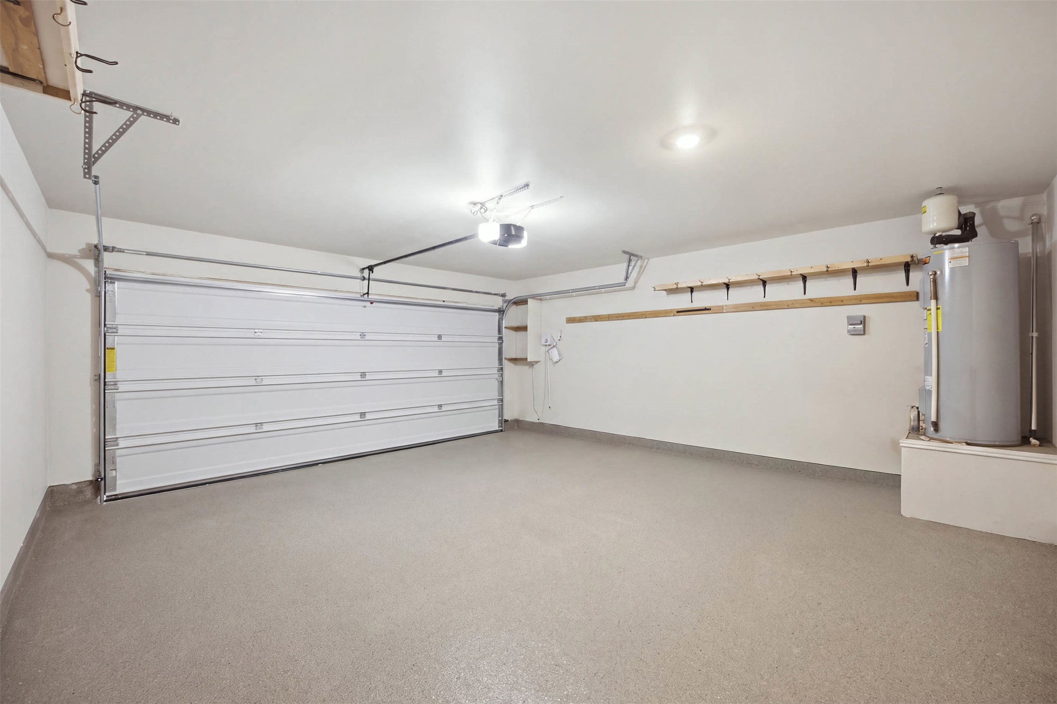 171 Cattle Queen Road Jarrell, TX 76537 - Photo 16 of 38 An immaculate attached garage showcases durable epoxy flooring and convenient overhead storage options.