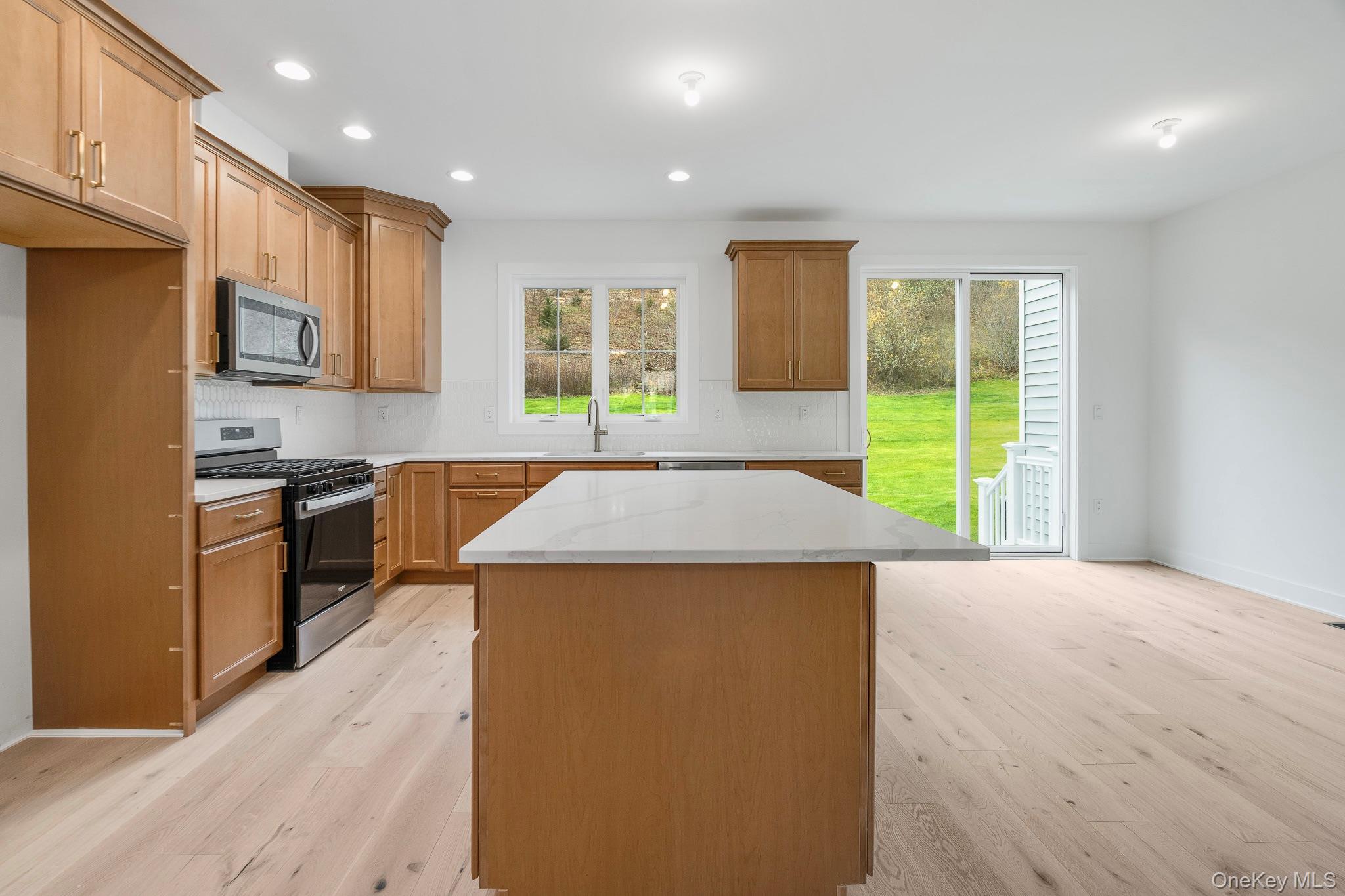 4044 Chestnut Rdg Road Fishkill, NY 12524 - Photo 9 of 26 a kitchen with stainless steel appliances kitchen island a stove a sink a refrigerator and a window