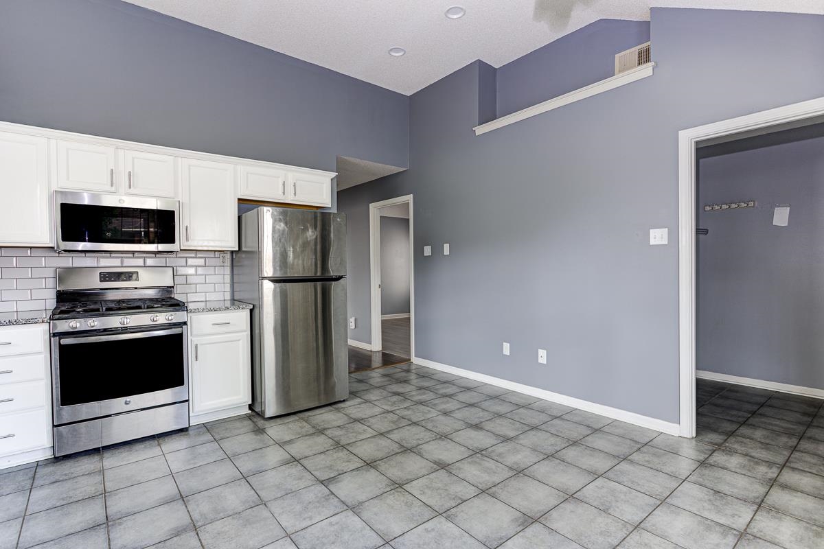 604 North Ericson Road Memphis, TN 38018 - Photo 5 of 16 Kitchen featuring stainless steel appliances, white cabinetry, and gray tile flooring