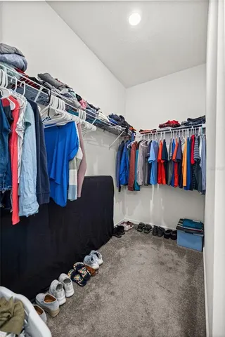 a view of walk in closet with clothes and shoes