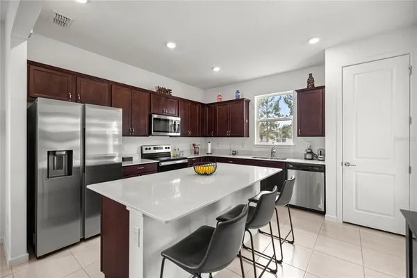 a kitchen with stainless steel appliances a sink a stove a refrigerator and cabinets