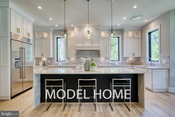 a open kitchen with stainless steel appliances granite countertop a refrigerator a sink dishwasher a dining table and chairs with wooden floor