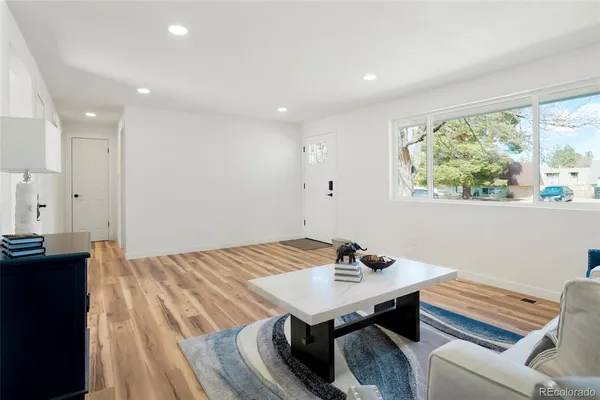 a kitchen with a sink and white cabinets next to a window