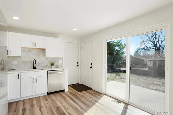 a kitchen with stainless steel appliances granite countertop a refrigerator a stove and a sink