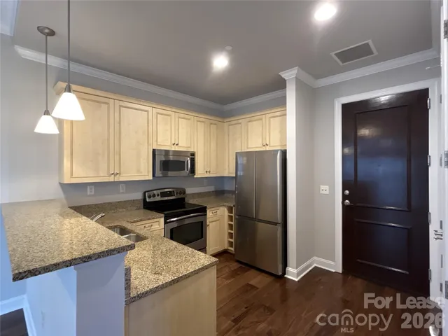 a kitchen with a refrigerator and a stove top oven
