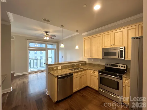a kitchen with wooden floors and stainless steel appliances