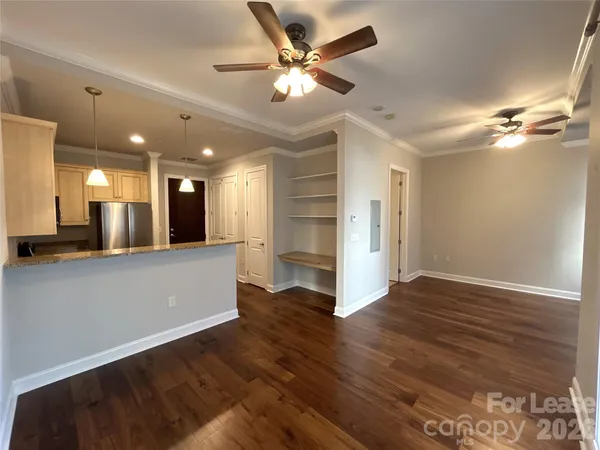 a view of an empty room with a kitchen