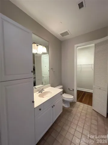 a spacious bathroom with a double vanity sink toilet and mirror