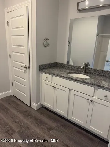 a bathroom with a granite countertop sink and mirror